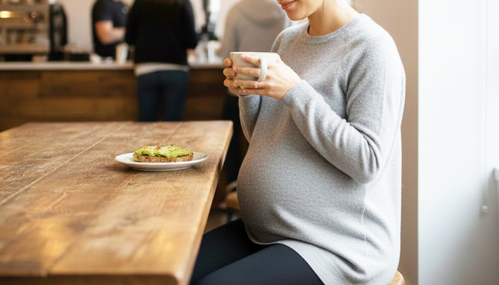 マタニティレギンスを着てカフェでランチをする女性