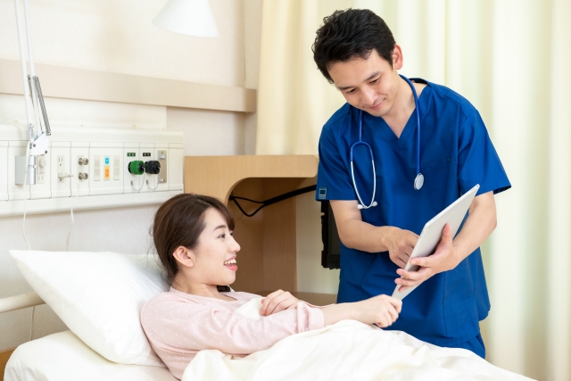 病院ベッドで説明を受ける女性